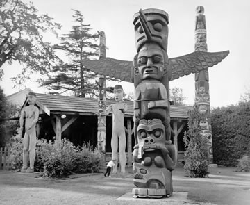 Kwakwaka’wakw Pole with other totem poles