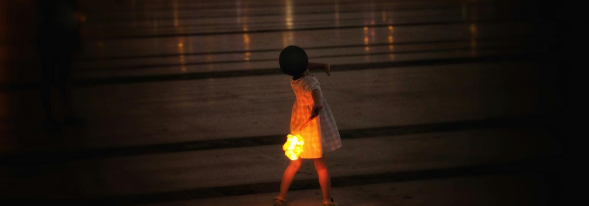 A child walks holding a lantern