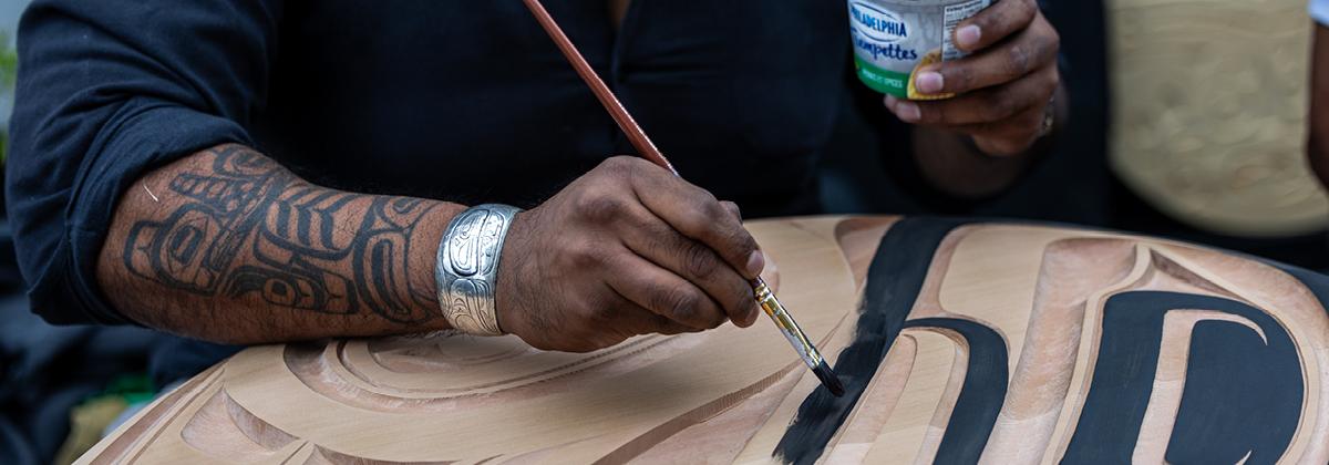 Hand painting a wood carving