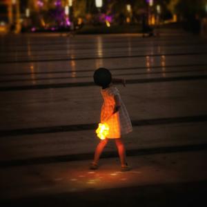 A child walks holding a lantern